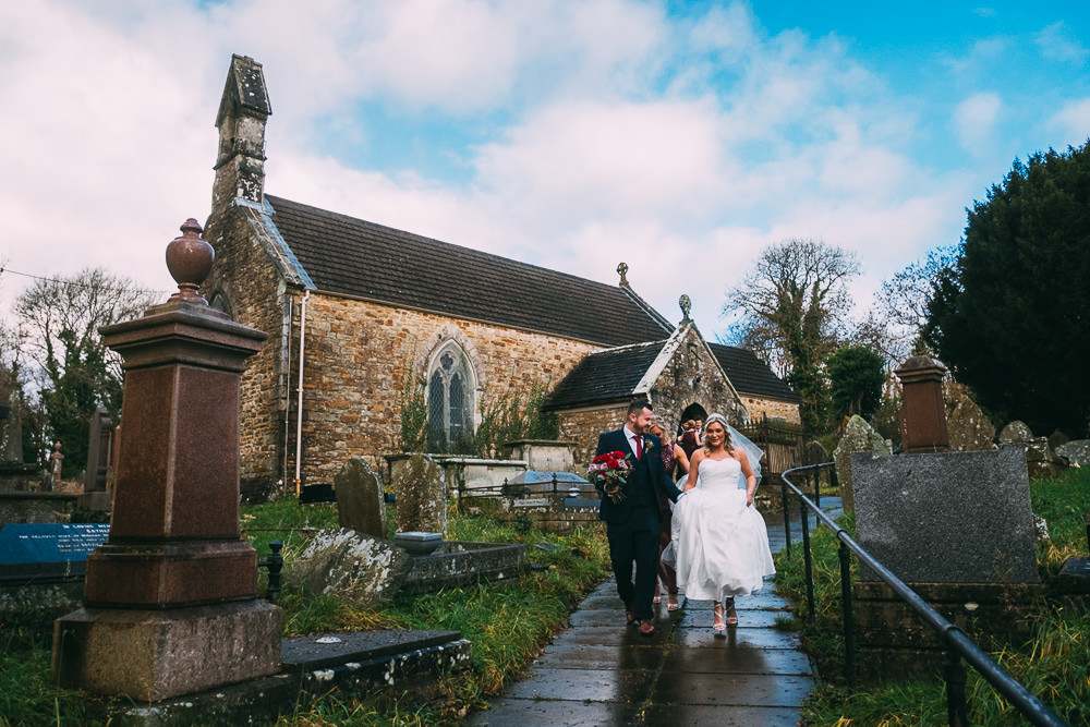 001 NEWLYWEDS MAKING THEIR EXIT WEDDING CEREMONY BRIDGEND CHURCH WEDDING PHOTOGRAPHY
